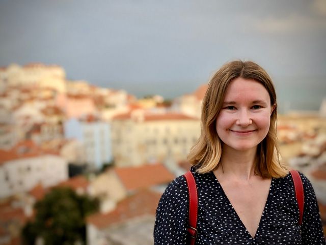 Head shot of Dr. Emma Banks with buildings in the background.