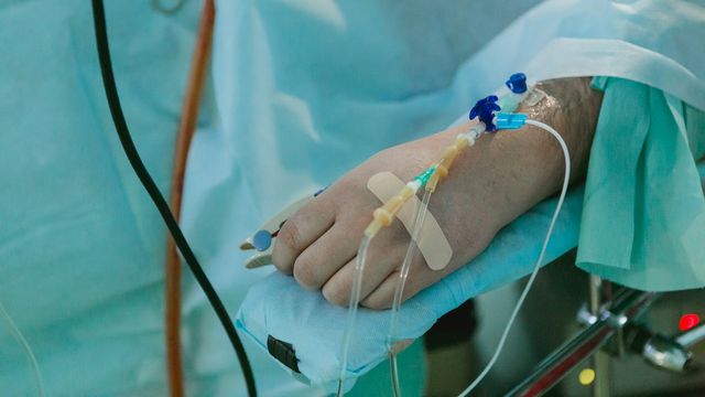 Medical tubes attached to a persons hand. 