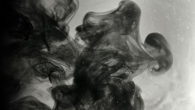 Black swirls into a grey background. 