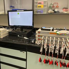 A lab setup with battery testing equipment linked up to a computer. 