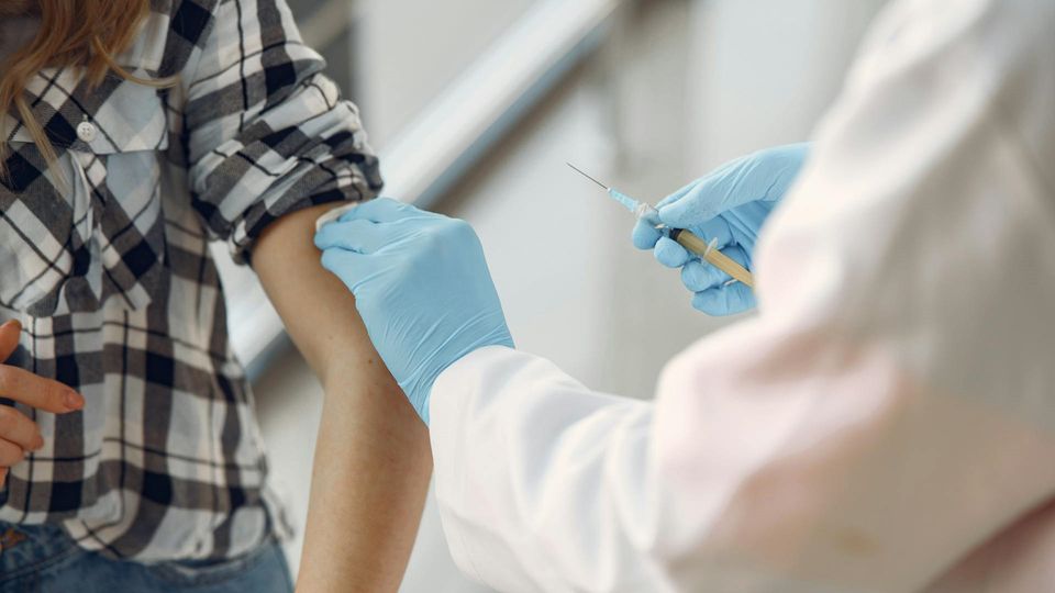 A medical professional prepares to administer a vaccination.