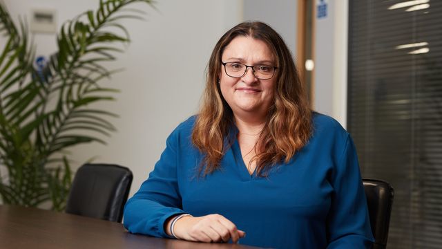 Headshot of Dr. Joanne Mason sitting at a desk.  